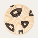 Woven basket with black and beige pattern on a white background