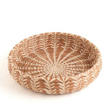 Woven basket with a circular design on a white background