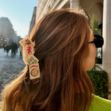 Person with a hair clip featuring mahjong tile designs outdoors