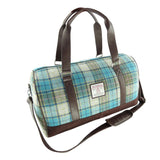 Plaid duffel bag with brown leather straps on a white background
