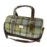 Plaid duffel bag with brown leather straps on a white background
