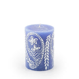 Blue candle with white floral design on a white background
