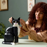 Woman holding a black and white cat-shaped LEGO model