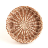 Woven basket with a circular pattern on a white background
