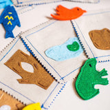 Colorful felt animal shapes on a grid-patterned fabric background