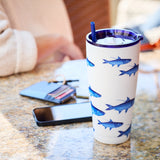 Tumbler with blue fish design on a marble surface with a phone and wallet in the background.