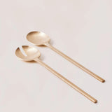 Two gold spoons on a light gray background