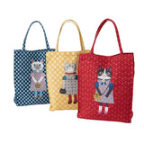 Three fabric tote bags with cat illustrations, shown in blue, yellow, and red patterns on a white background.