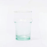 A clear recycled glass cup with a solid green tint and slight imperfections.