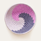 Decorative bowl with pink, purple, and white spiral pattern on a light background