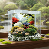 Miniature garden scene with a small pagoda, rocks, and plants inside a transparent box on a wooden surface.
