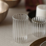 Two clear glass tumblers with a striped pattern.