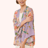 Woman wearing a floral kimono-style garment on a white background