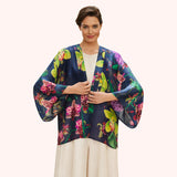 Woman wearing a colorful floral kimono-style jacket on a white background