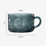 Green glass mug with decorative patterns and measurements on a white background