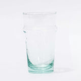 A clear recycled glass cup with a solid green tint and slight imperfections.