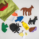 Colorful felt animal shapes on a white surface with a green fabric item.