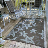 Starfish patterned rug on a wooden deck with rocking chairs and a small table.