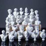 Collection of white classical busts on a reflective surface with a dark background