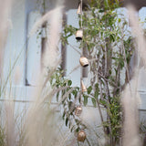 Decorative wind chime with hanging bells in a garden setting