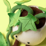 Plush toy with green leaves and a neutral background