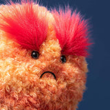Plush toy with orange fur and red tufts on a dark blue background