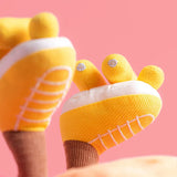 Yellow plush roller skates on a pink background