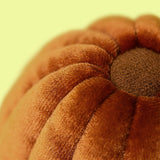 Close-up of a textured brown fabric with a yellowish-green background