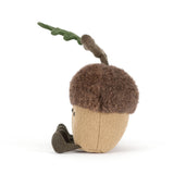 Two plush acorns with faces and a branch on a white background