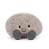 Plush toy resembling a round small stone with a smiling face on a white background
