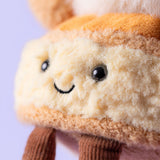 Close-up of a plush toy with a smiling face on a light purple background