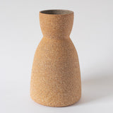A conical ceramic vase with a textured, earthy finish on a neutral background.