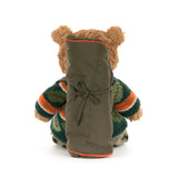 Stuffed teddy bear wearing a sweater and backpack on a white background