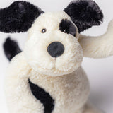 Close-up of a plush toy dog with black spots on a white background