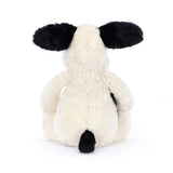 White plush dog toy with black ears and tail on a white background