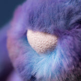 Close-up of a fluffy purple and blue bunny with a textured surface.