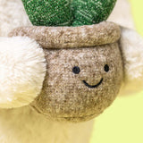 Close-up of a plush toy with a smiling face and green leaves.