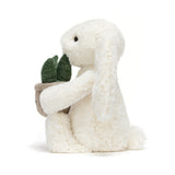 White plush bunny holding a small plant pot on a white background