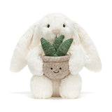Plush toy rabbit holding a potted plant on a white background
