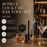 A 10-piece cocktail bar tool set displayed on a wooden bar counter with two rocks glasses filled with amber liquor, a martini glass, a metal shaker, strainer, muddler, and other bar accessories. The left side features promotional text and feature icons on a warm brown background.