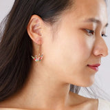 Close-up of a person wearing a unique earring with a white background
