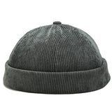 A green corduroy knit beanie hat with a folded cuff, shown against a white background.