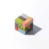 A multicolored gemstone Soma Cube Puzzle with a shadow on a white background.