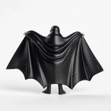 Figurine of Dracula in a black cape and suit on a white background