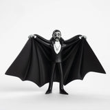 Figurine of Dracula in a black cape and suit on a white background