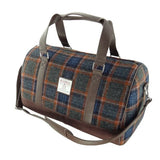 Plaid duffel bag with brown leather straps on a white background