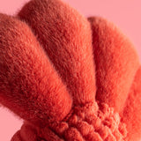 Close-up of a fluffy red object against a pink background