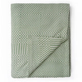Folded green patterned blanket on a white background