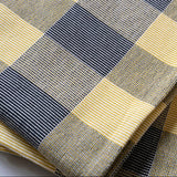 Close-up of a fabric with a checkered pattern in blue, yellow, and gray.