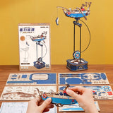 Model building kit with a partially assembled model and packaging on a wooden surface.